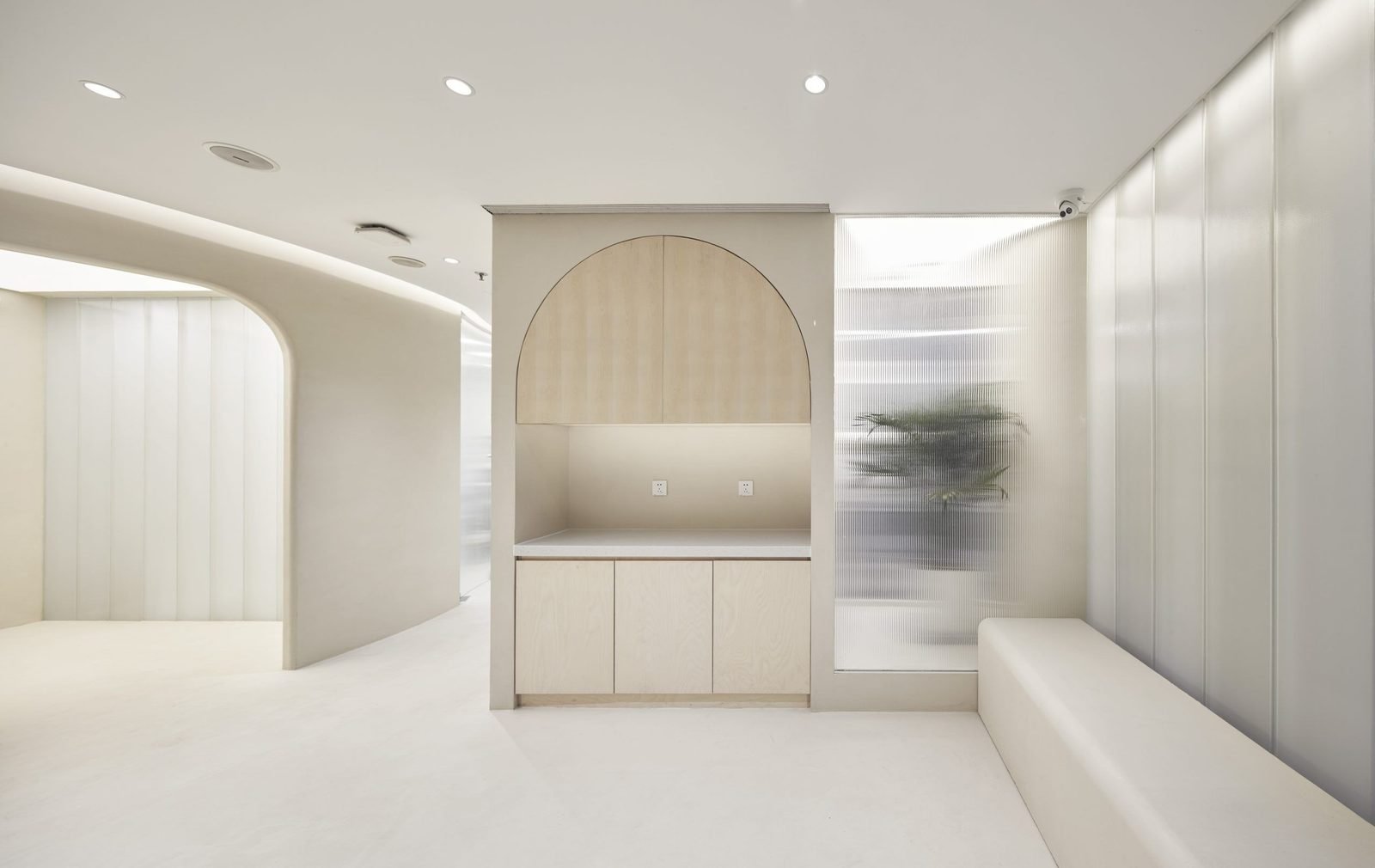 Sala clínica blanca y luminosa con un nicho en arco