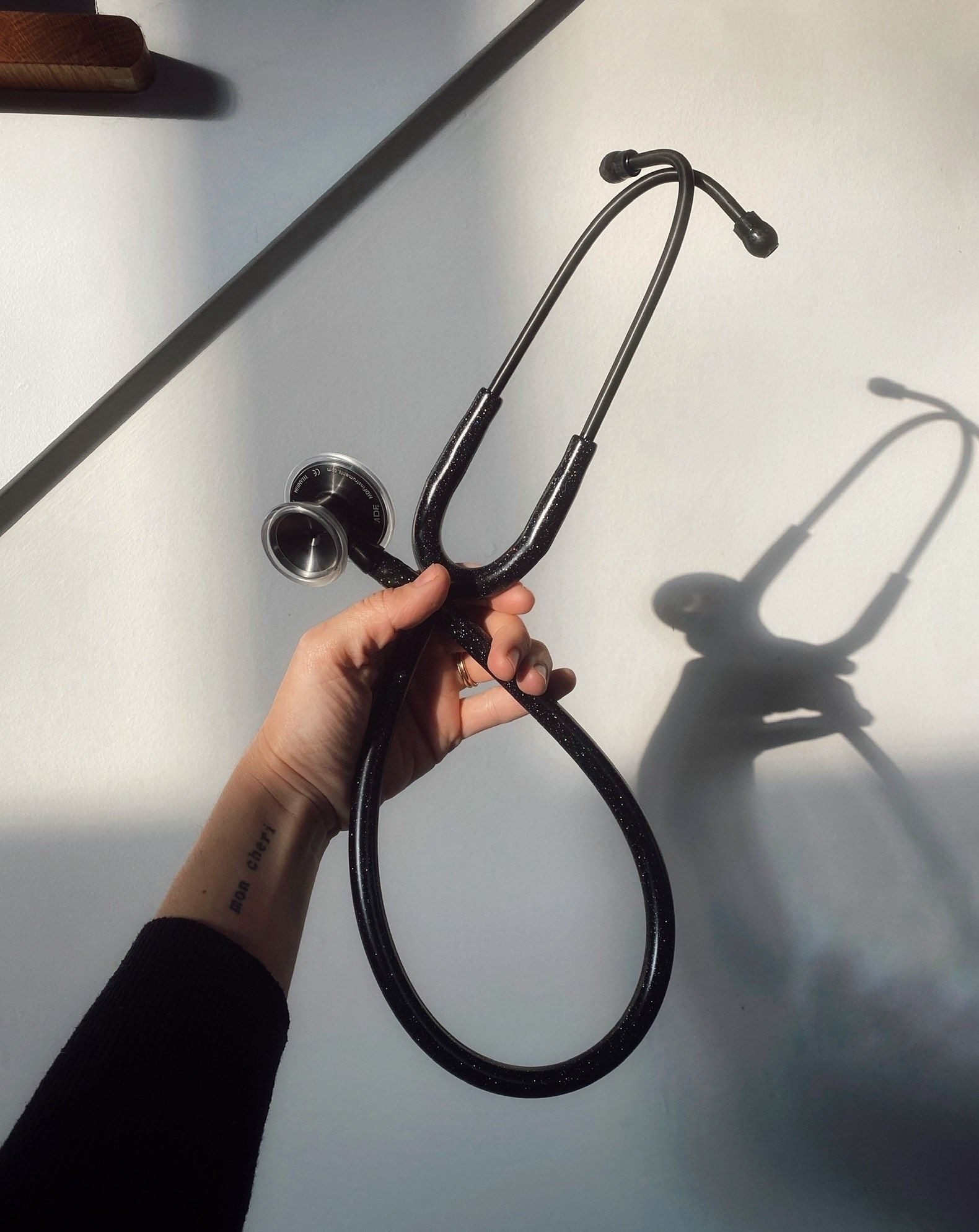 Mano sosteniendo un fonendoscopio a contraluz
