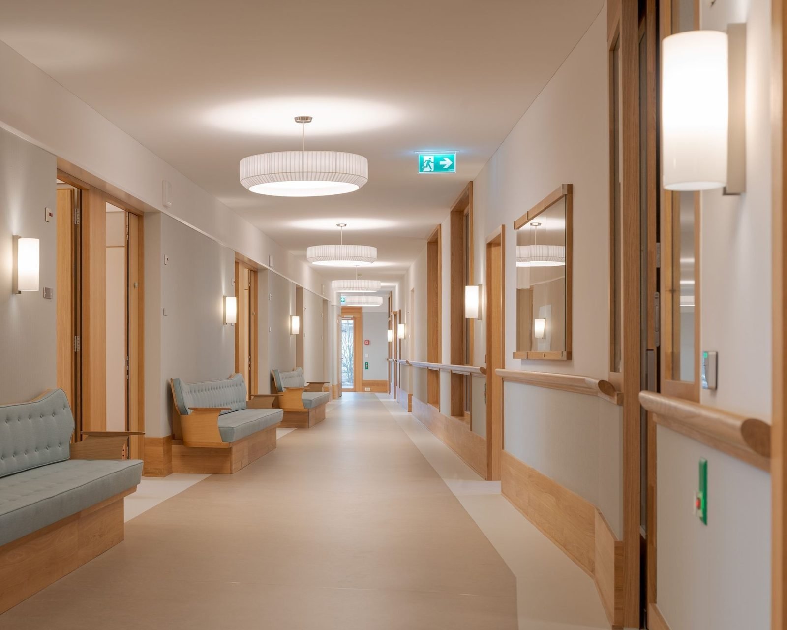Pasillo de hospital cálido con madera y bancos